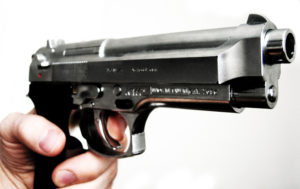 holding handgun with finger on trigger